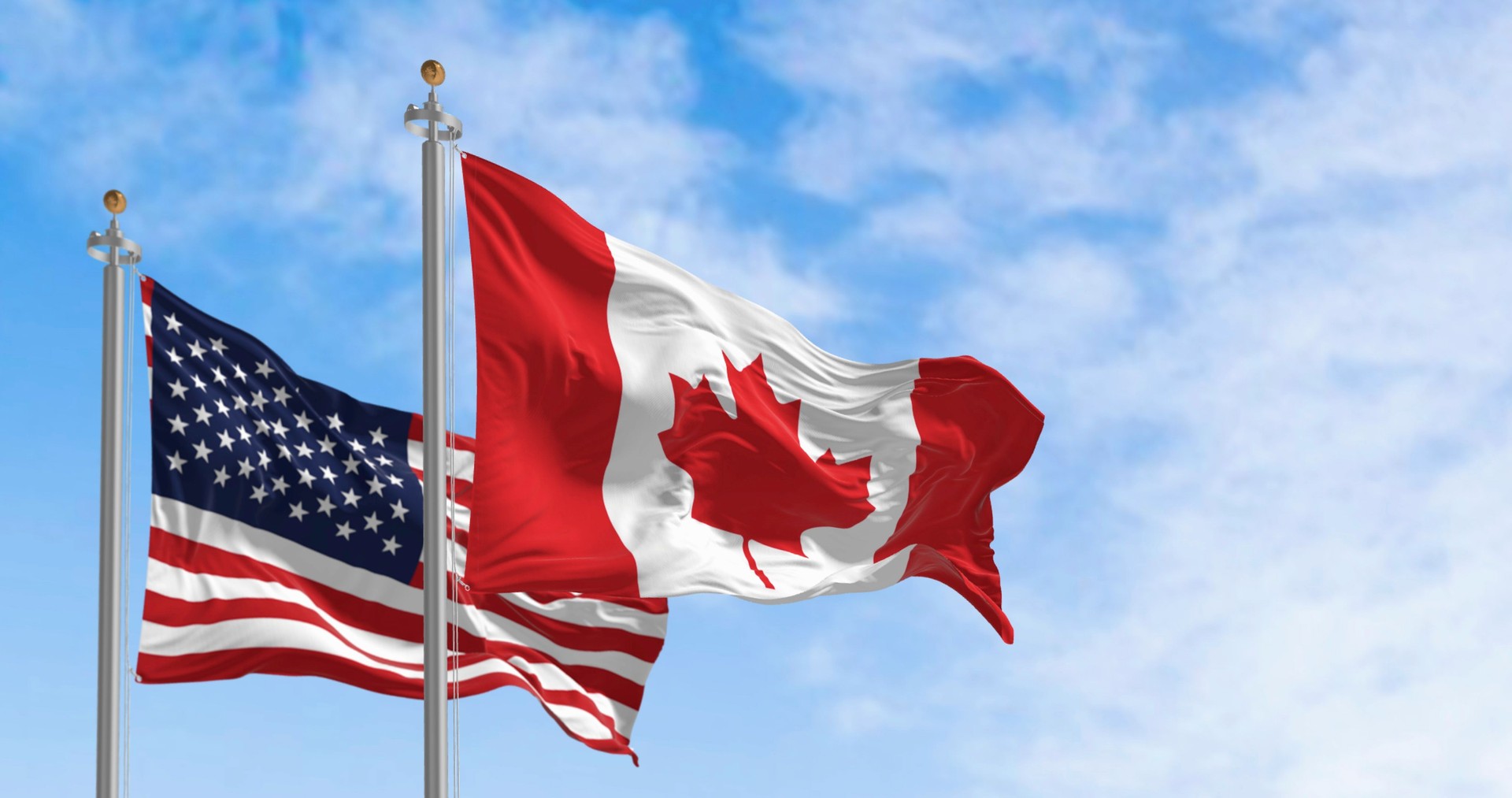 Canada and American national flags waving in the wind on a clear day. For people or businesses shipping from Canada or the US